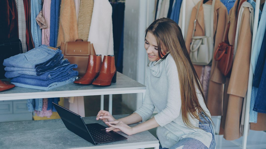 Local shop owner using a laptop, representing AI visibility for local businesses.
